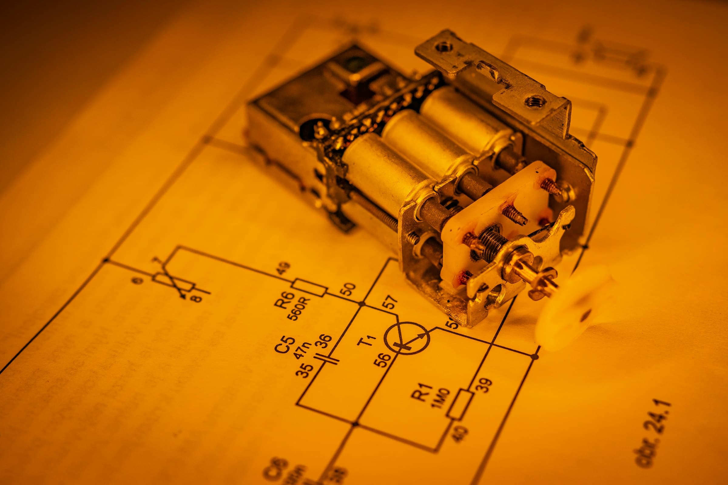 A relay resting on an electrical schematic under warm light