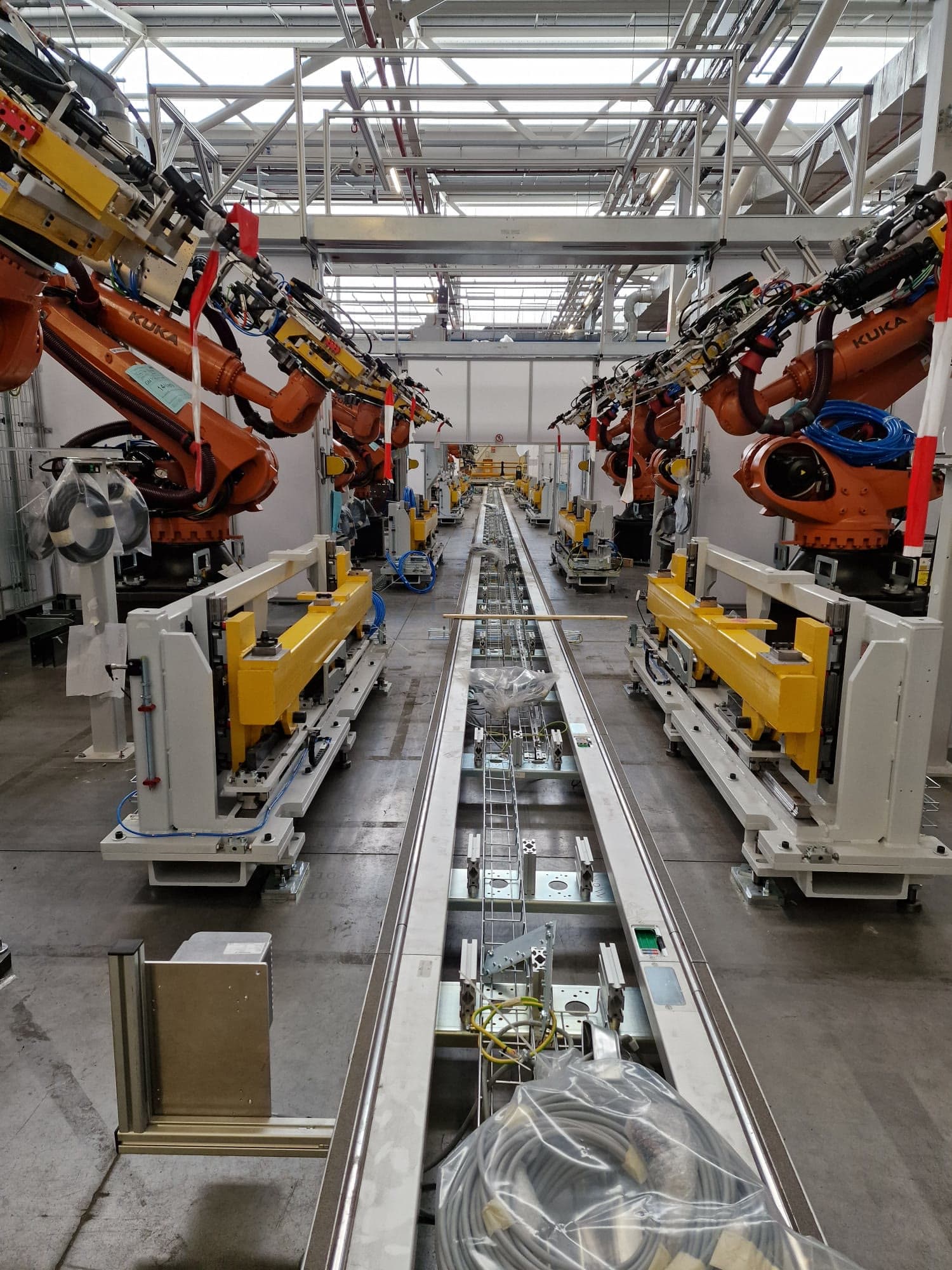 Robot cells either side of a conveyor on a new propulsion line