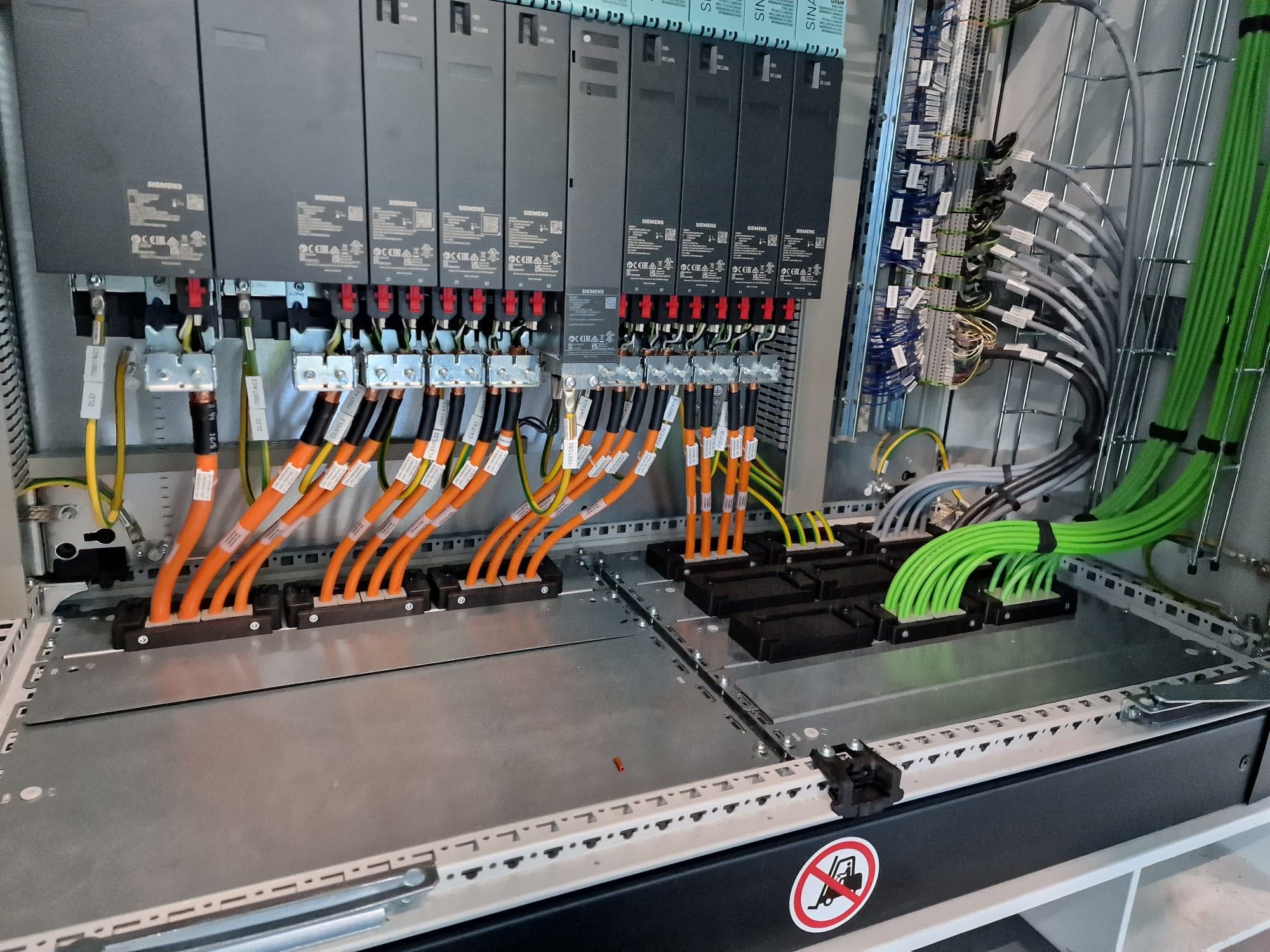Drive cabinet with motor cables and network cabling terminated on a busbar