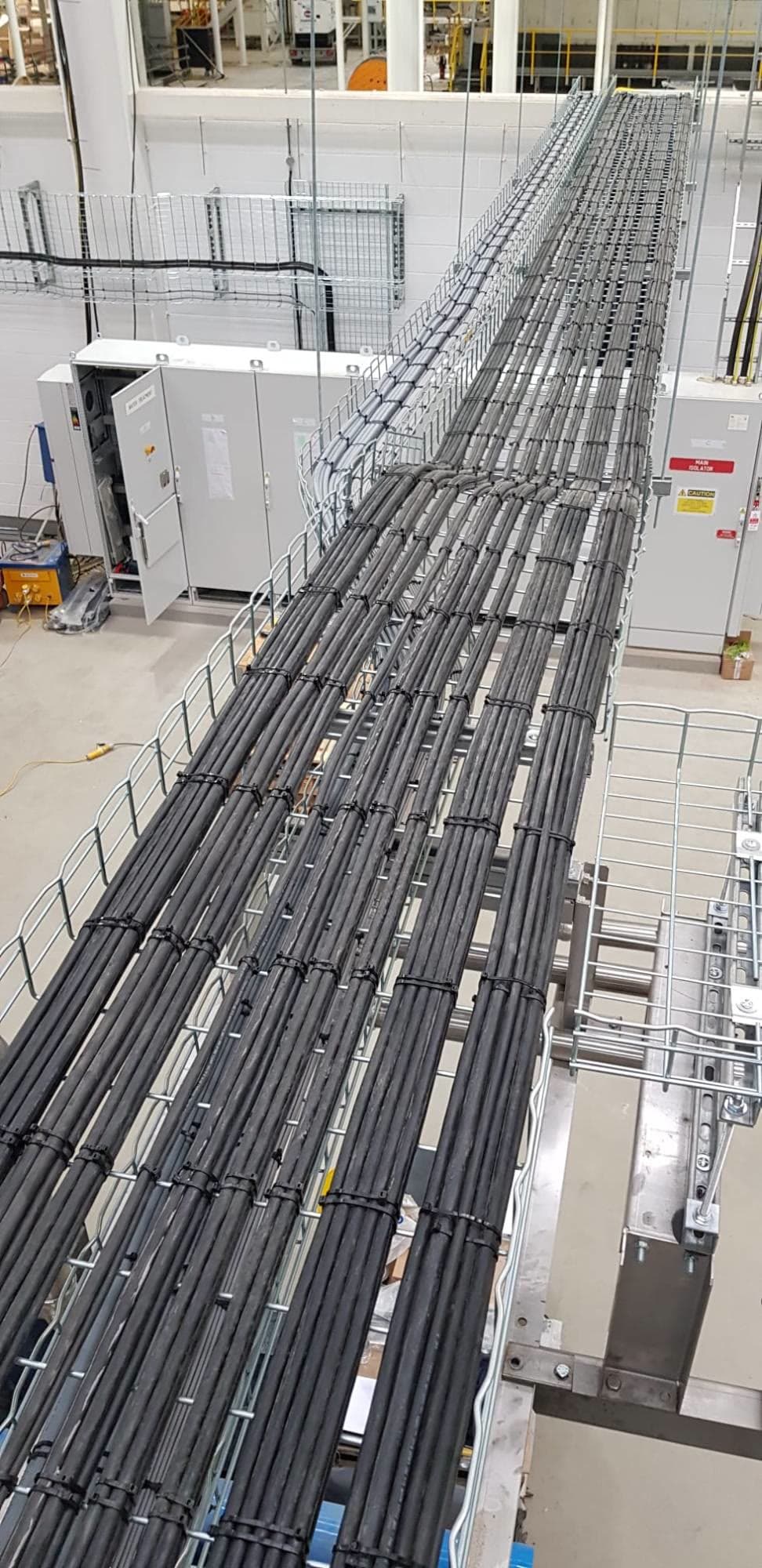Sub-mains cabling on basket tray running between distribution panels